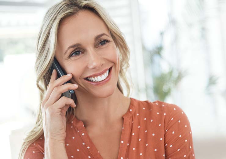 A woman happy on the phone after becoming a new Hot Iron angel